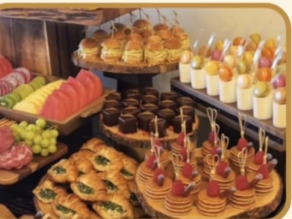 Tabla de fiambres, frutas, postres en vaso y bocados calientes